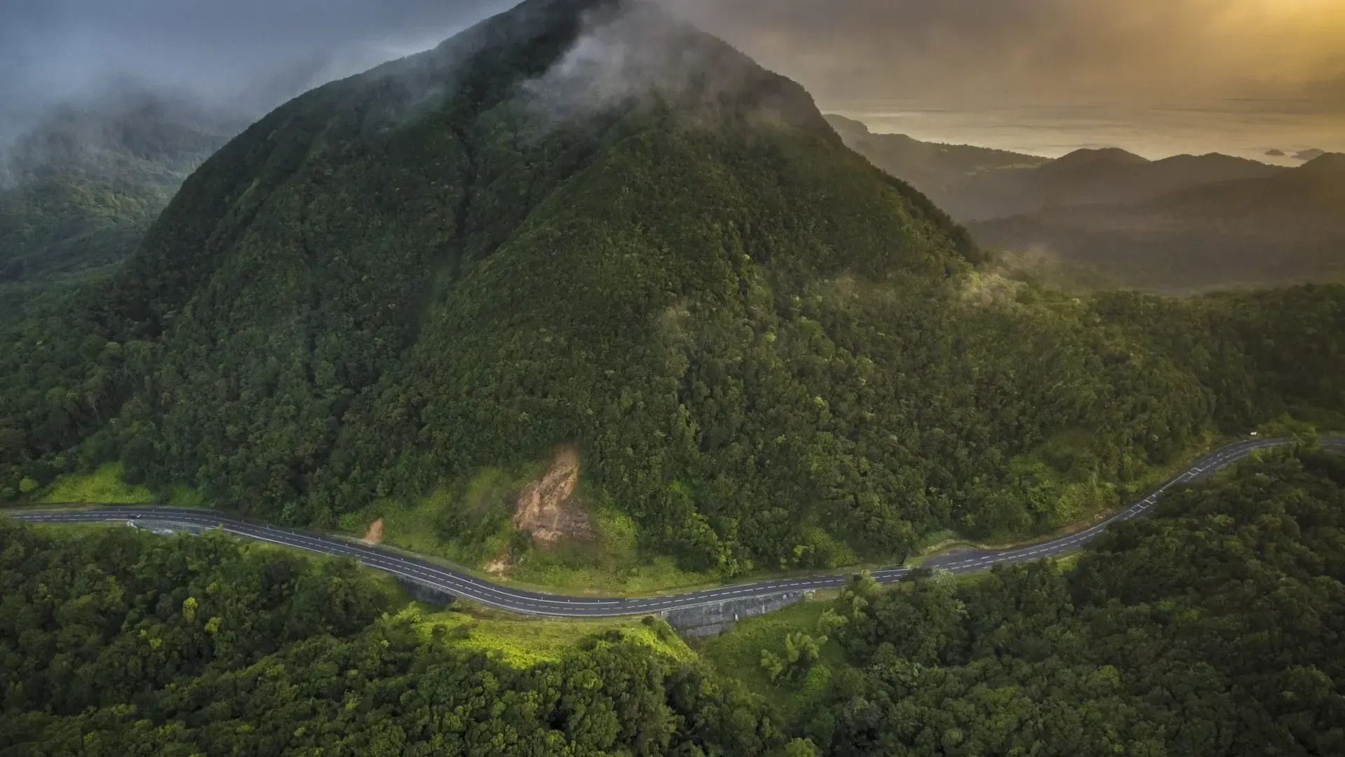 Route sinueuse de la traversée en guadeloupe avec végétation tropicale luxuriante